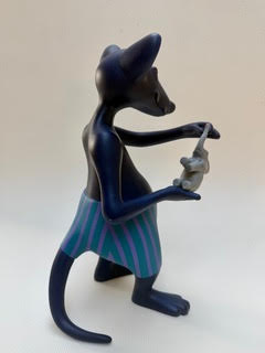 La souris et l'éléphant Personnage félin stylisé tenant un petit objet, vêtu d'un short rayé.