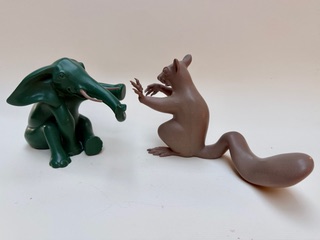 Éléphant et écureuil joueur Un éléphant en plastique vert et un écureuil marron se font face.
