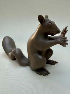 Ecureuil Sujets : sculpture d'écureuil en bronze avec une queue enroulée.