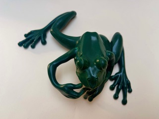 Grenouille verte Grenouille verte en plastique avec des pattes étendues.