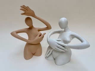 Dame 3 et 4 Deux sculptures stylisées en forme humaine, l'une marron et l'autre blanche, en poses expressives.