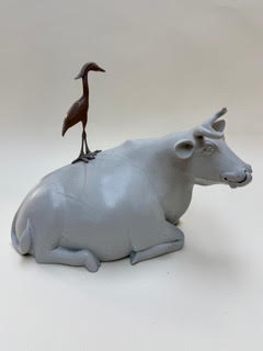 Ma Normandie - la vache et le héron Une vache grise en position couchée avec une grue posée sur son dos.